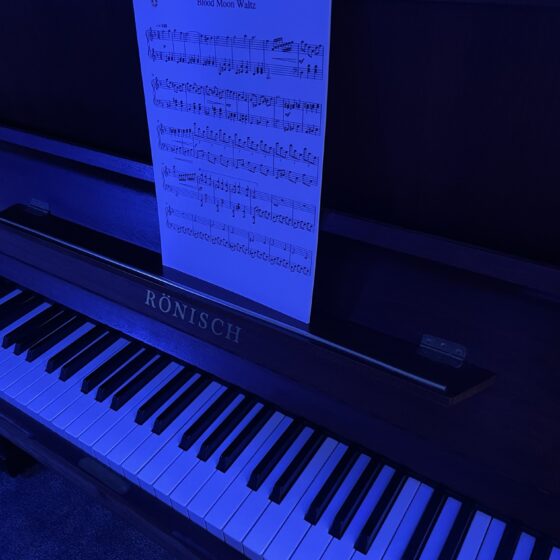 My piano, bathed in dark blue light in my newly opened studio