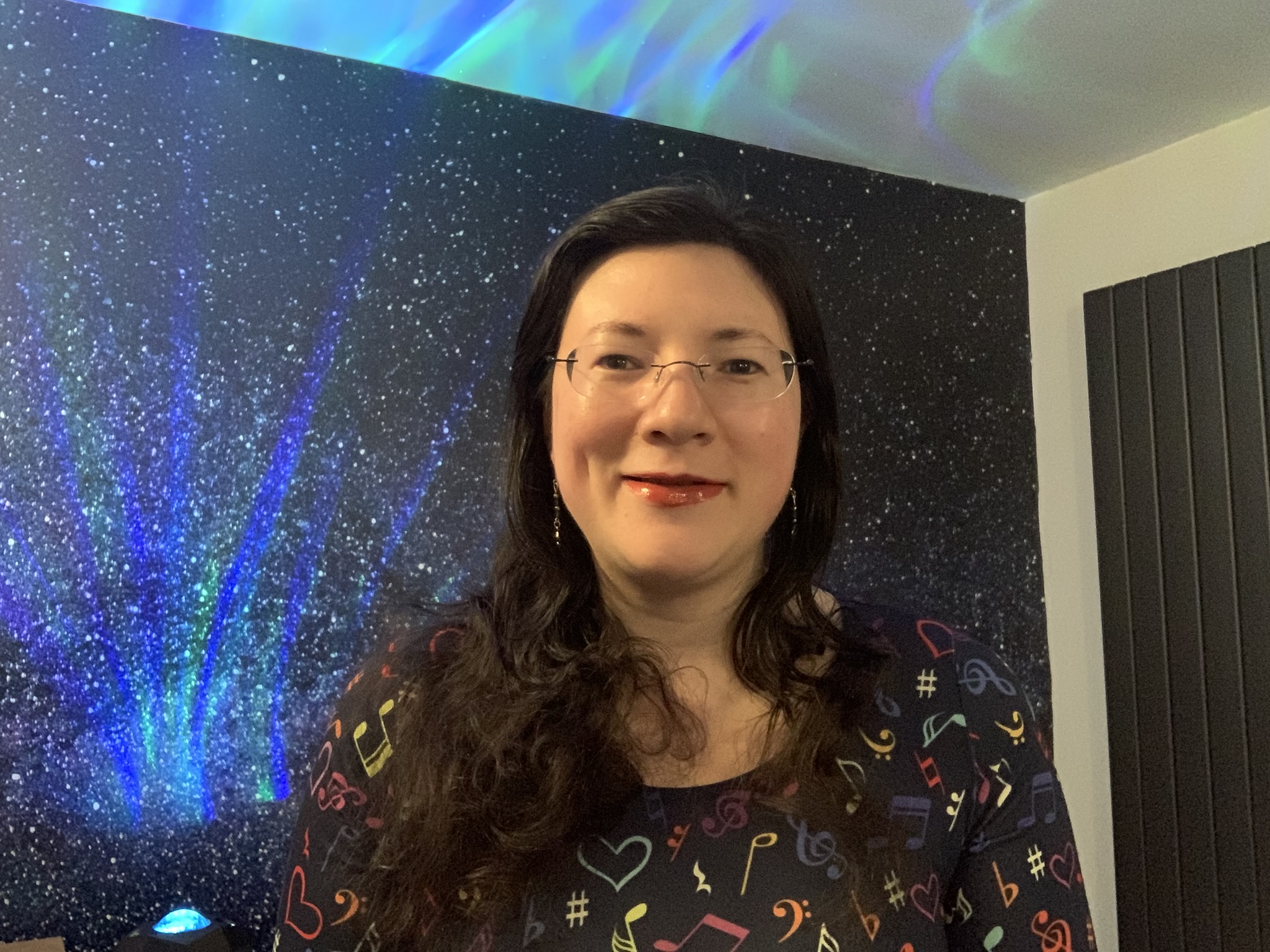 Taking Visibility to a New Level! 1 A selfie of me wearing a popsy dress talking visibility and my book, with galaxy background and aurora borealis lighting.