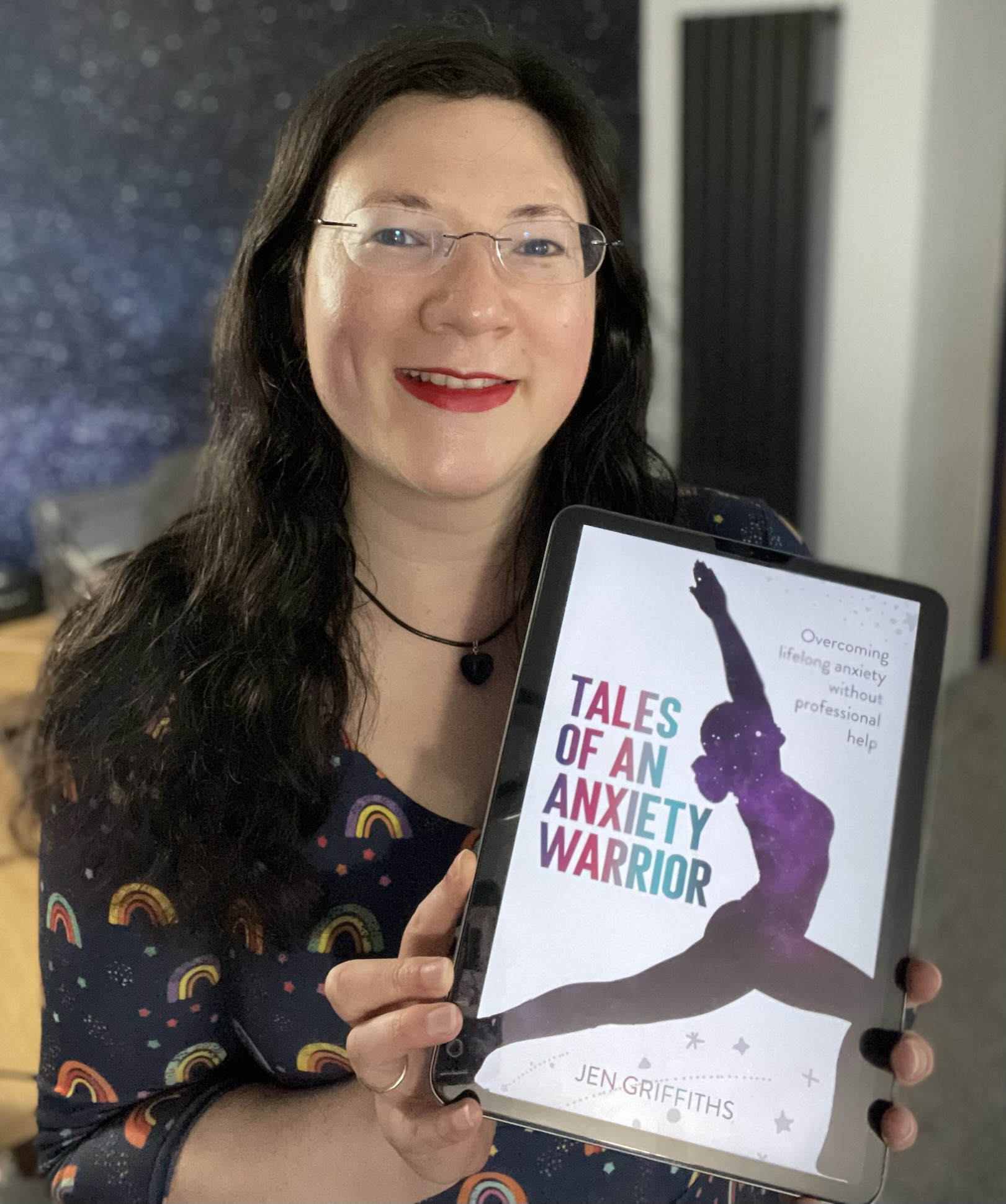 Full Steam Ahead! Tales of an Anxiety Warrior is coming soon! 1 A selfie of me in a rainbow dress. holding a digital copy of my book's cover, looking excited! Tales of an Anxiety Warrior