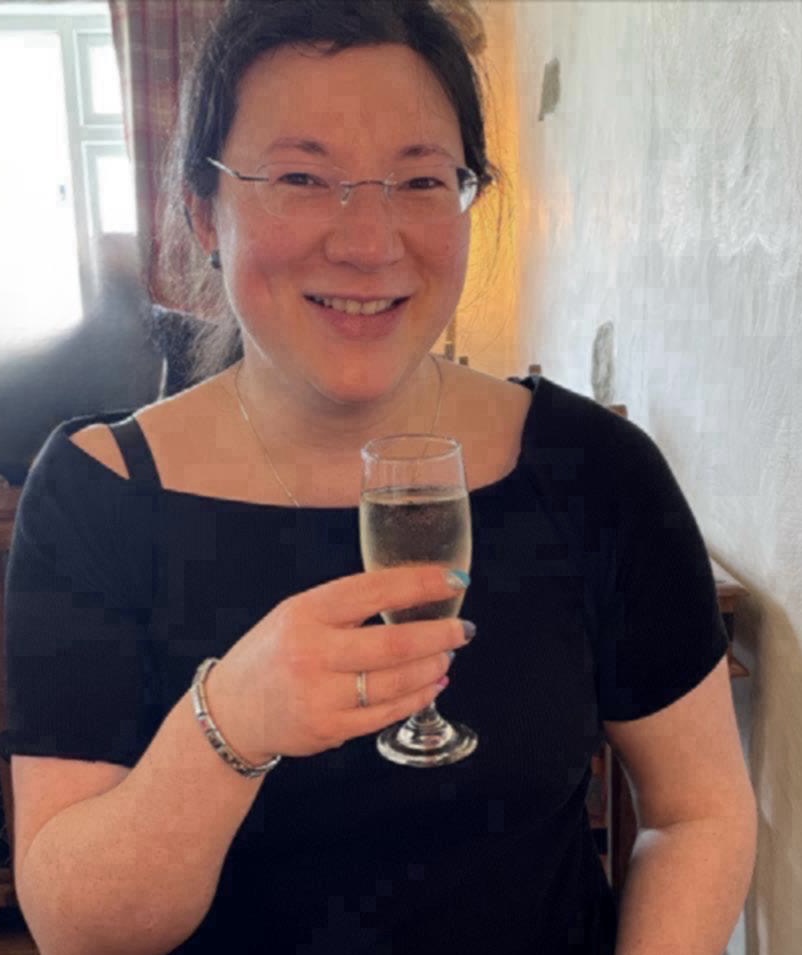 A photo of a beaming Jen, holding a glass of prosecco to toast her new book!