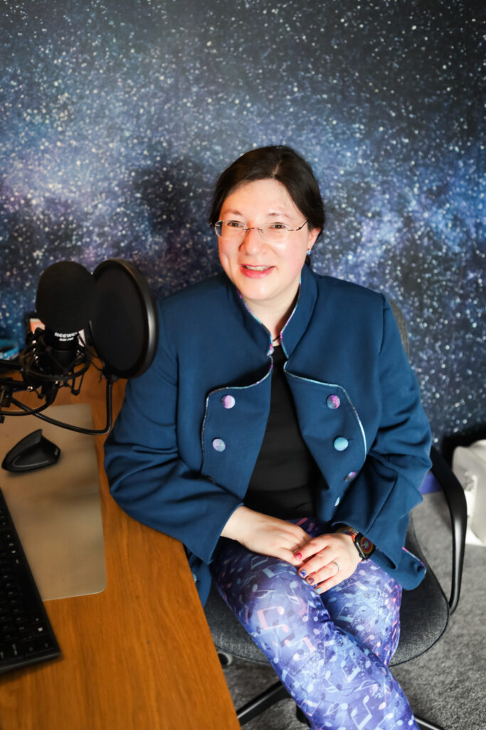 I had a Brand Photoshoot and it was so much fun! 46 Smiling at the camera, poised for my podcast. In music themed leggings, and tailor made jacket.