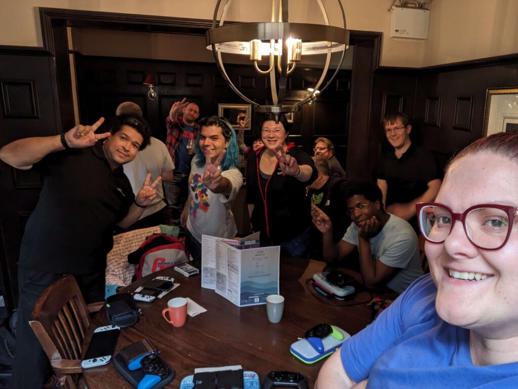 A group selfie, with Tash at the foreground, Dave, Marc and Jen are the focus making the peace sign. 