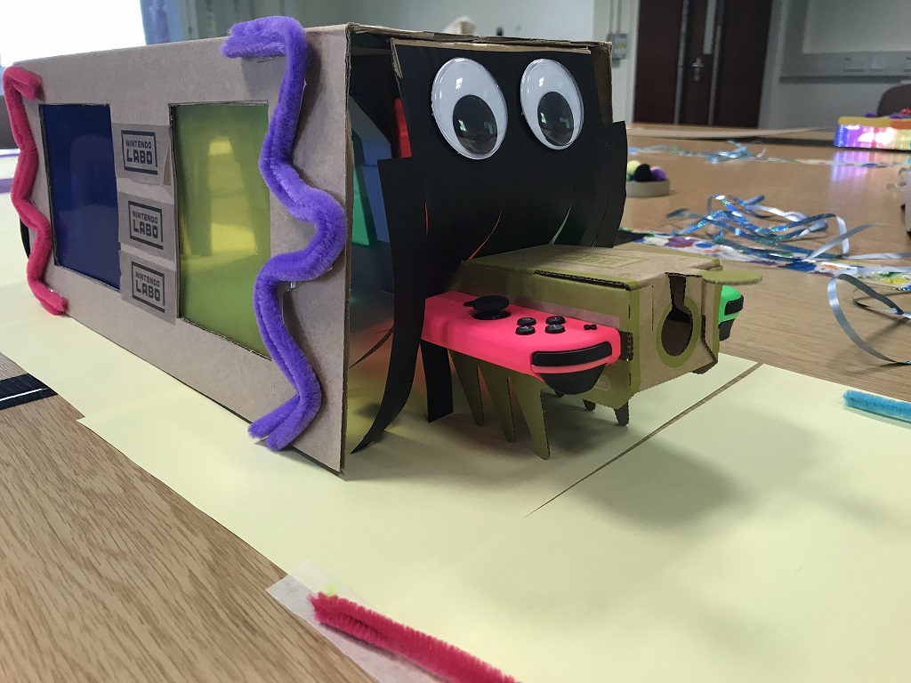 "Beating Tetris is not a life goal" 1 paper crafted "Munch monster" for Nintendo Labo bug on an obstacle course. big googly eyes, and a "curtain" which the bug goes through to the other side.