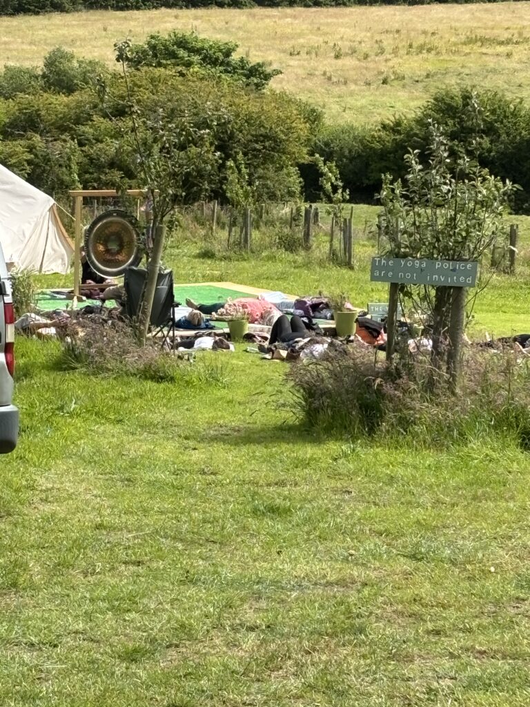 Speaker at a Brand New Yoga Festival- June 2024 - a Major 2024 Goal accomplished! 6 The gong bath outside - group of people lying on their yoga mats on the decking