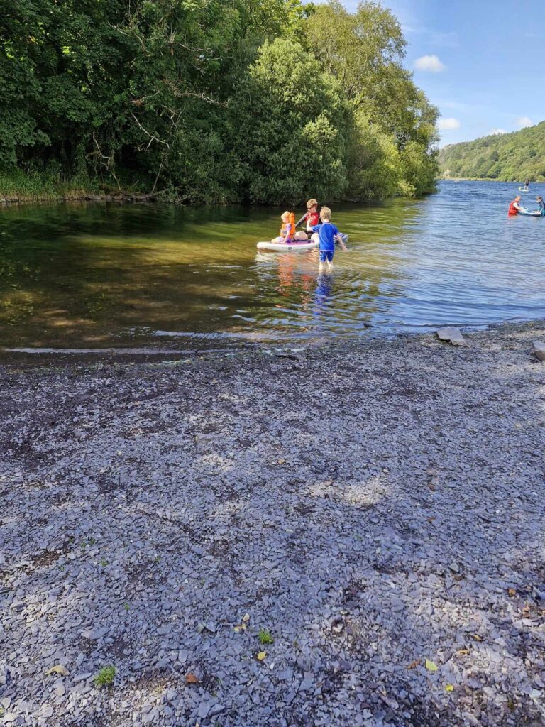 Making the most of the Summer Holidays 2024! 15 A group of people sharing a paddle board on the lake.