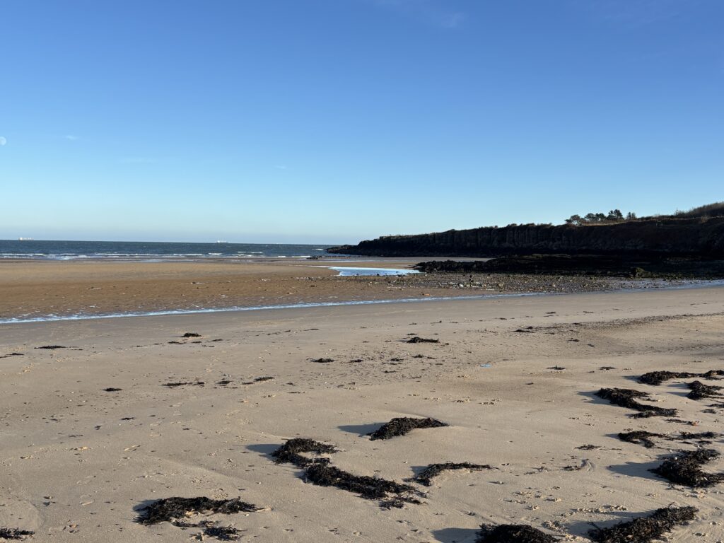2025- New Year, New Chapter! 4 a picture of Lligwy beach at low tide, with blue skies.