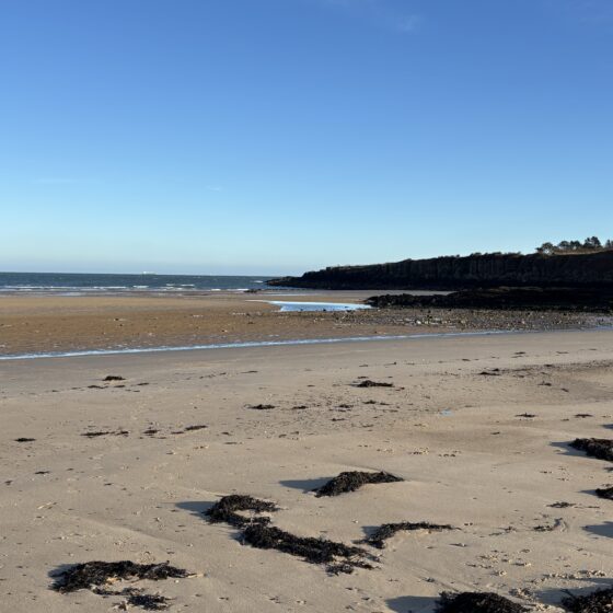A shot across Lligwy beach with blue skies