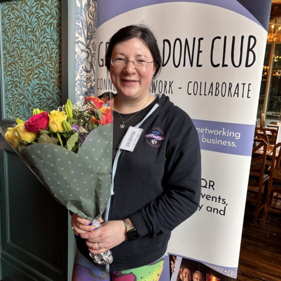 photo of me holding a bunch of colourful flowers, which match my colourful leggings.