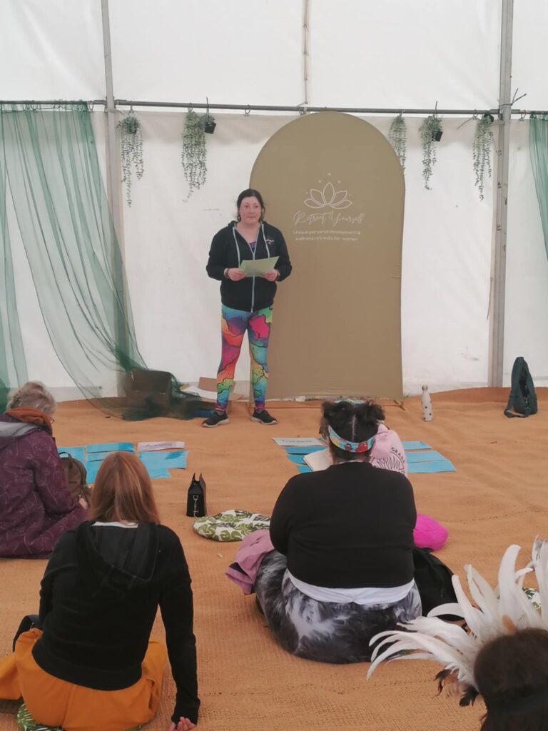 Festivals of 2025 Fulfilled & 3 Public Speaking Goals Smashed! 10 picture of me talking to the audience, holding one of my flash cards. Rainbow leggings, branded hoodie.