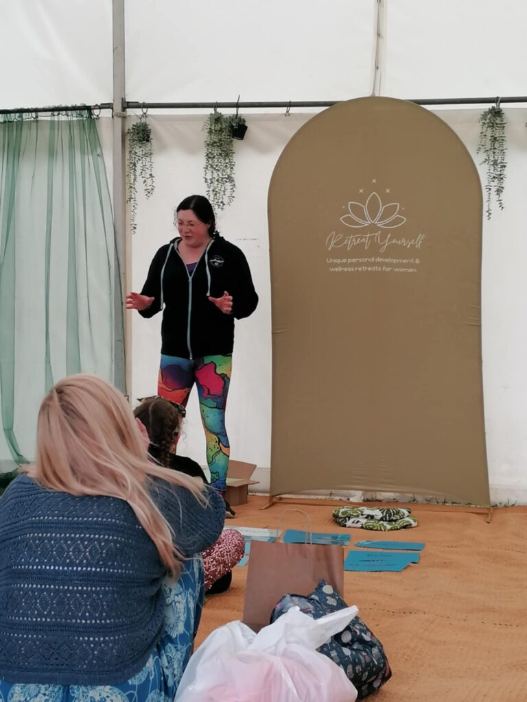 Festivals of 2025 Fulfilled & 3 Public Speaking Goals Smashed! 15 picture of me gesturing at the audience. Rainbow leggings, branded hoodie.