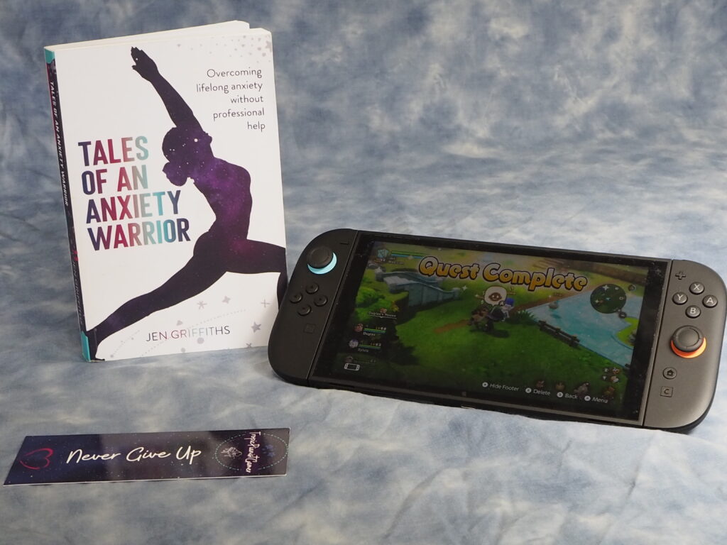 A Spontaneous Adventure to Learn Photography..! (and the Power of Networking) 22 A shot of my book, bookmark and switch 2 console against the cloud backdrop, showing a scene "Quest Complete" on Fantasy Life i