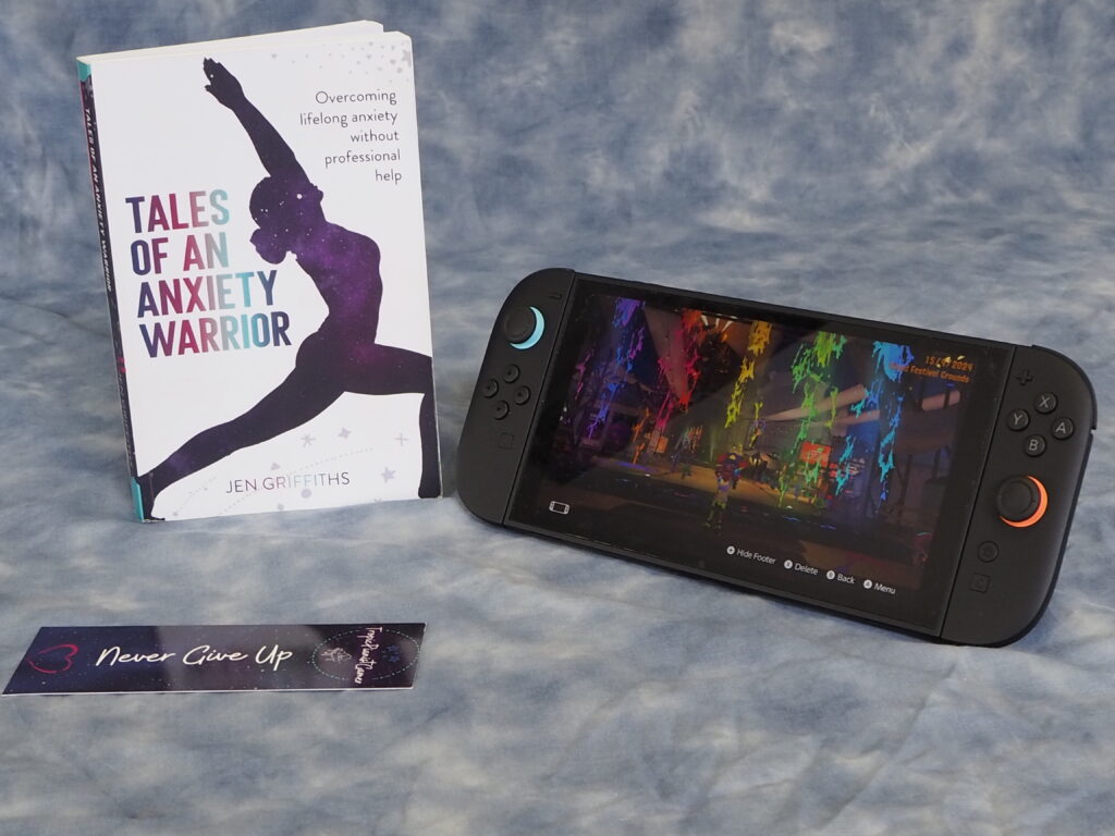 A Spontaneous Adventure to Learn Photography..! (and the Power of Networking) 23 A shot of my book, bookmark and switch 2 console against the cloud backdrop, showing a scene from a Splatfest on Splatoon 3