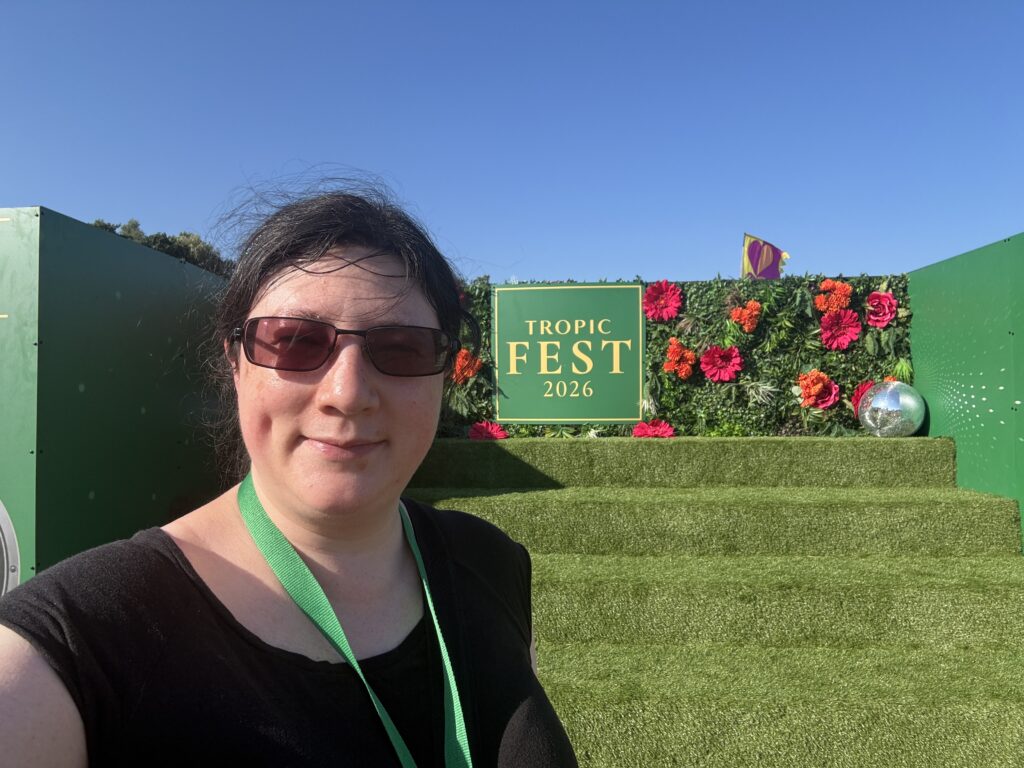 Summer 2026 is a Great Balance! 13 A selfie of me stood by one of the Tropic Fest signs.